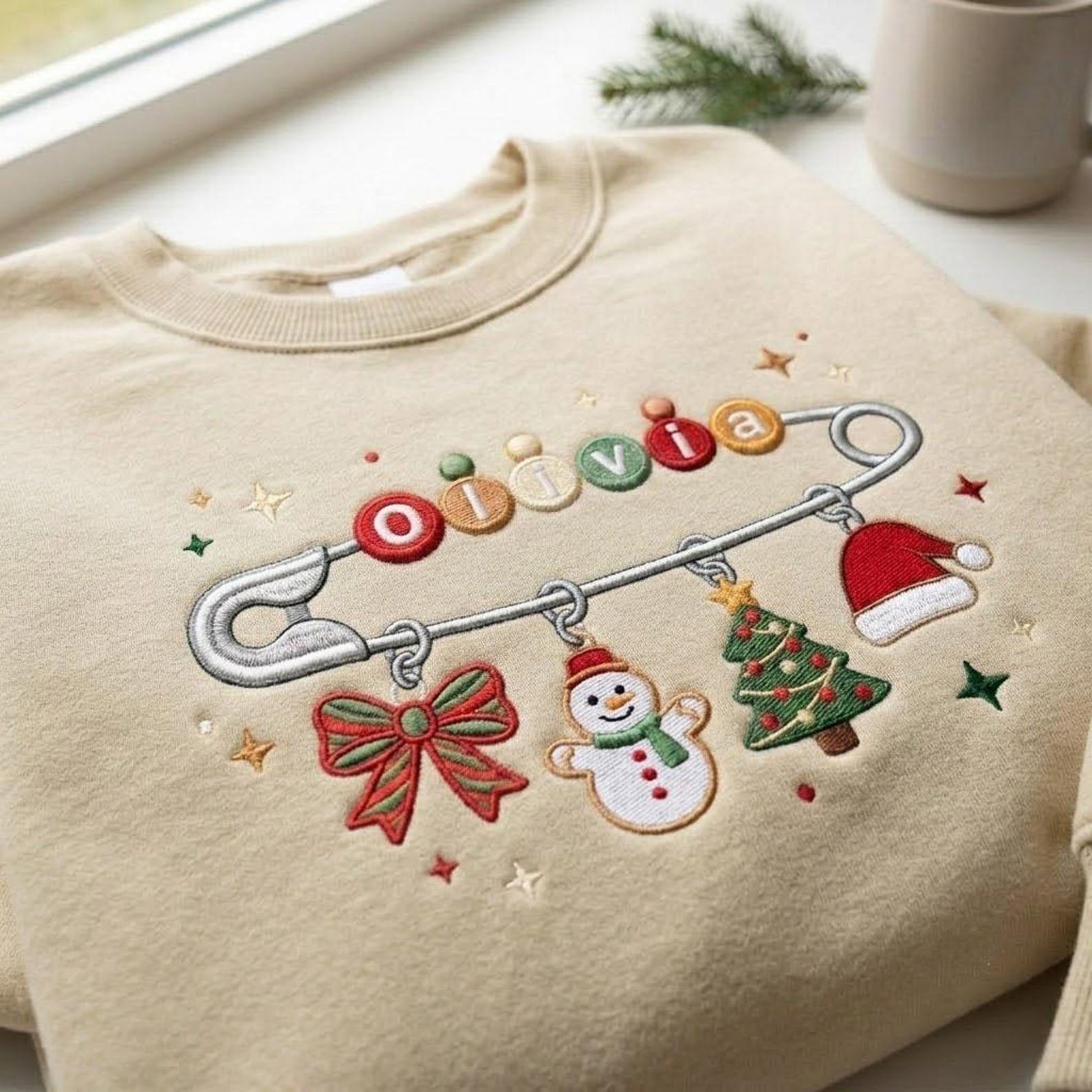 Personalized Christmas Name Sweatshirt, Custom Embroidered Safety Pin Crewneck, Holiday Charm Sweater, Christmas Family Gift 1